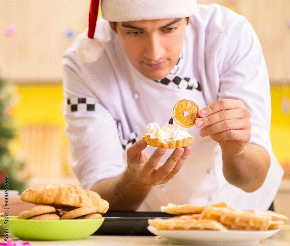 Young chef husband working in kitchen at Christmas eve Young chef husband working in kitchen at Christmas eve