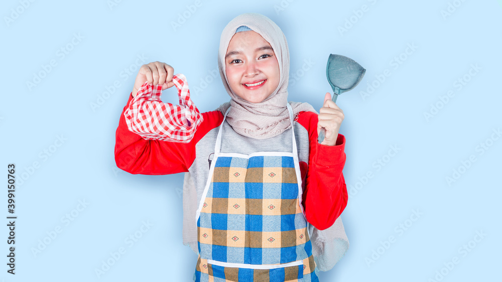 Asian woman holding a lunch box and spatula. she cooking healthy food, Dieting Concept. Healthy Lifestyle. Cooking At Home. Prepare Food, isolated on blue Asian woman holding a lunch box and spatula. she cooking healthy food, Dieting Concept. Healthy Lifestyle. Cooking At Home. Prepare Food, isolated on blue
