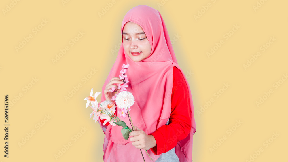 Spring, happiness and celebration concept. Close-up portrait of lovely romantic smiling asian hijab girl, holding flowers, receive bouquet on date, standing on bright background Spring, happiness and celebration concept. Close-up portrait of lovely romantic smiling asian hijab girl, holding flowers, receive bouquet on date, standing on bright background