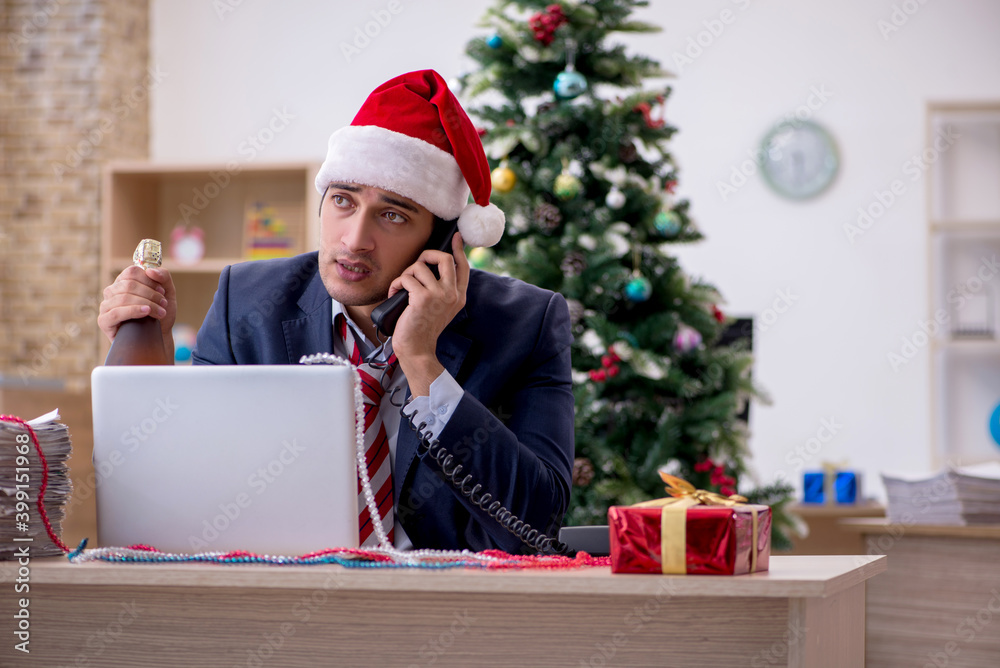Young male employee celebrating new year in the office