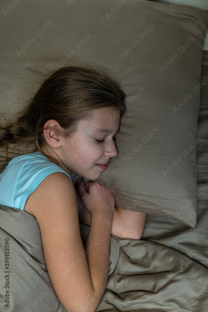 Girl with dark hair sleeps in brown bed Girl with dark hair sleeps in brown bed