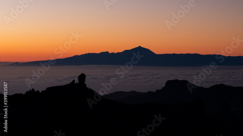 sunset over the mountains with views of Roque Nublo and Teide, located in Spain, Canary Island, Gran Canaria. Also you can see a sea of clouds