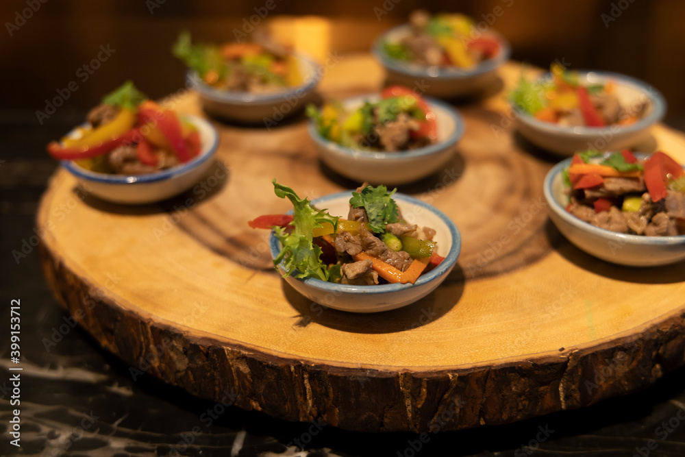 Plate with small starters; roasted beef with vegetables and sesame dressing
