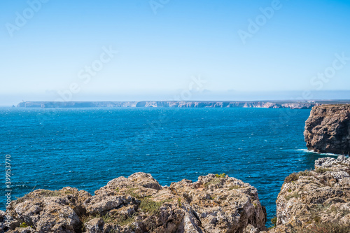 Cliffs by the sea with São Vicente Cape in Sagres sunken in the horizon, Algarve PORTUGAL