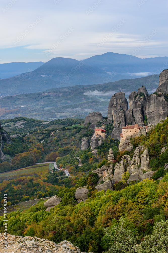 Obraz premium Roussanou and Αgios Nikolaos monastery, an unesco world heritage site, located on a unique rock formation above the village of Kalambaka during fall season.