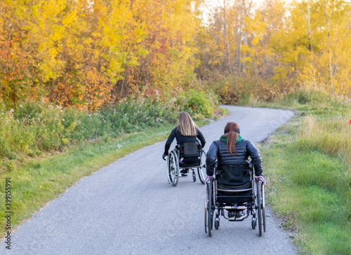 Women / Girl in Wheelchair on Path Rolling up Path Fall / Autumn for Workout