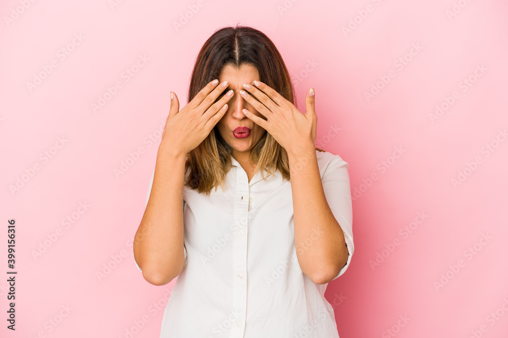 Young indian woman isolated on pink background afraid covering eyes with hands.