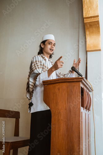 Portrait of muslim male preacher speech sharing about islam during prayer time in the mosque photo