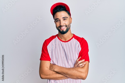 Canvas Print Young man with beard wearing baseball uniform happy face smiling with crossed arms looking at the camera