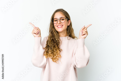 Young caucasian woman pointing to different copy spaces, choosing one of them, showing with finger.