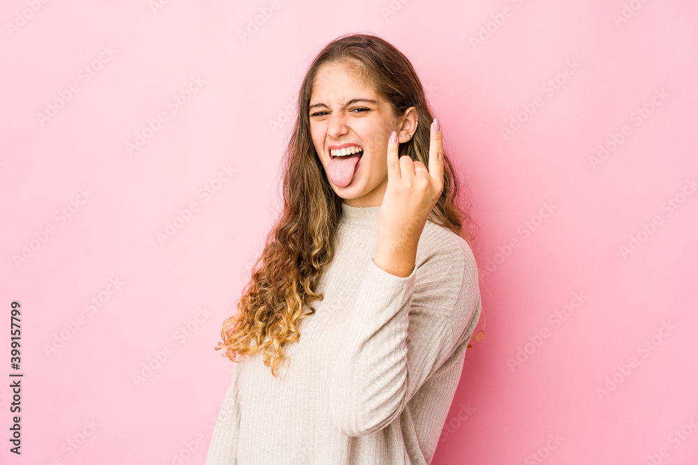 Young caucasian woman showing rock gesture with fingers Young caucasian woman showing rock gesture with fingers