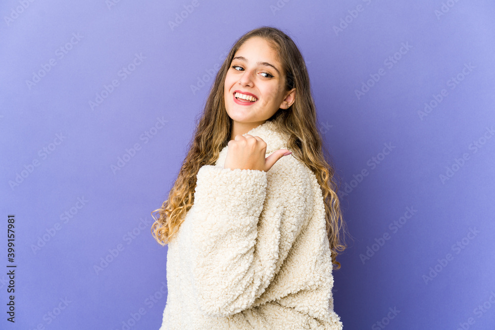 Young caucasian cute woman points with thumb finger away, laughing and carefree. Young caucasian cute woman points with thumb finger away, laughing and carefree.