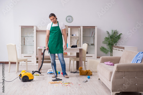Young male contractor cleaning the flat after kids' party