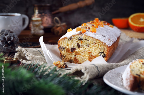 Christmas cake with candied orange and dried fruits, coffee and New Year decoration