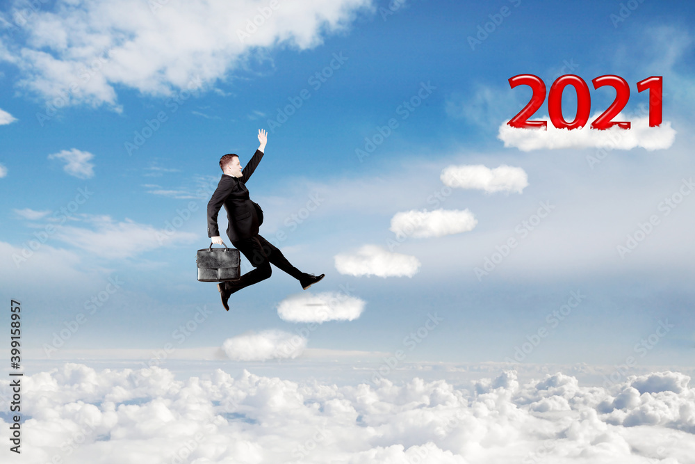 Businessman running on clouds toward 2021 number Businessman running on clouds toward 2021 number