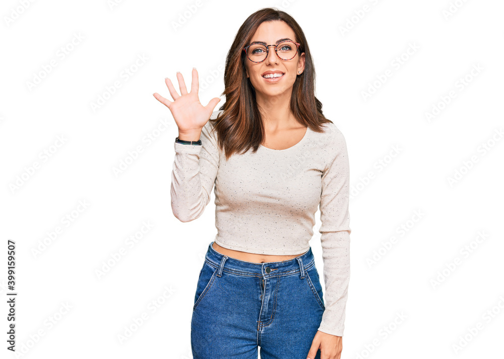 Young brunette woman wearing casual clothes and glasses showing and pointing up with fingers number five while smiling confident and happy. Young brunette woman wearing casual clothes and glasses showing and pointing up with fingers number five while smiling confident and happy.