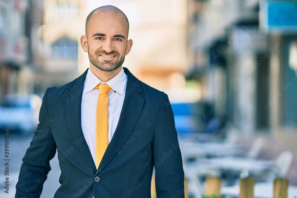 Young hispanic bald businessman smiling happy standing at the city. Young hispanic bald businessman smiling happy standing at the city.