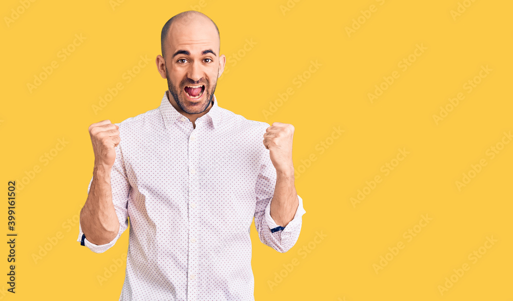 Young handsome man wearing elegant shirt celebrating surprised and amazed for success with arms raised and open eyes. winner concept. Young handsome man wearing elegant shirt celebrating surprised and amazed for success with arms raised and open eyes. winner concept.