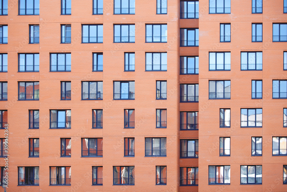 Wall of an apartment building with many windows.