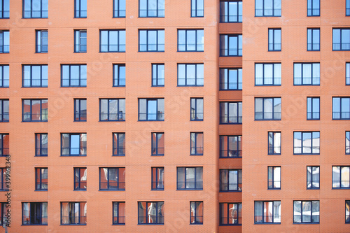 Wall of an apartment building with many windows.