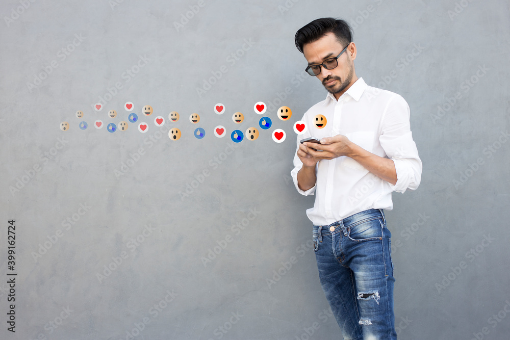 Social media concept with young man using smartphone with giving icon rating during watching live with copy space Social media concept with young man using smartphone with giving icon rating during watching live with copy space