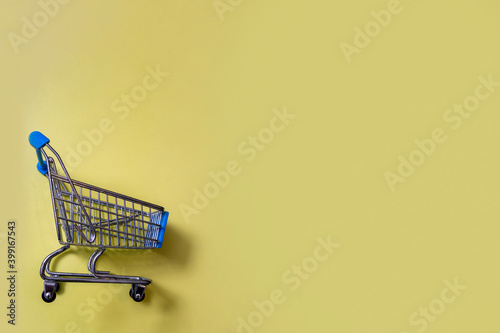 trade. shopping cart on a yellow background. copy space