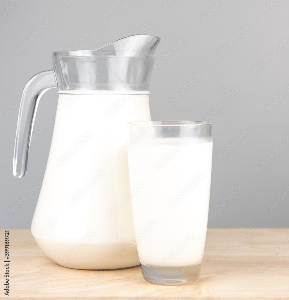 Bottle milk for a drink on a wooden table..Jug of fresh milk and glass on a gray background, .Milk consumption nutritious, and healthy dairy products concept. Bottle milk for a drink on a wooden table..Jug of fresh milk and glass on a gray background, .Milk consumption nutritious, and healthy dairy products concept.