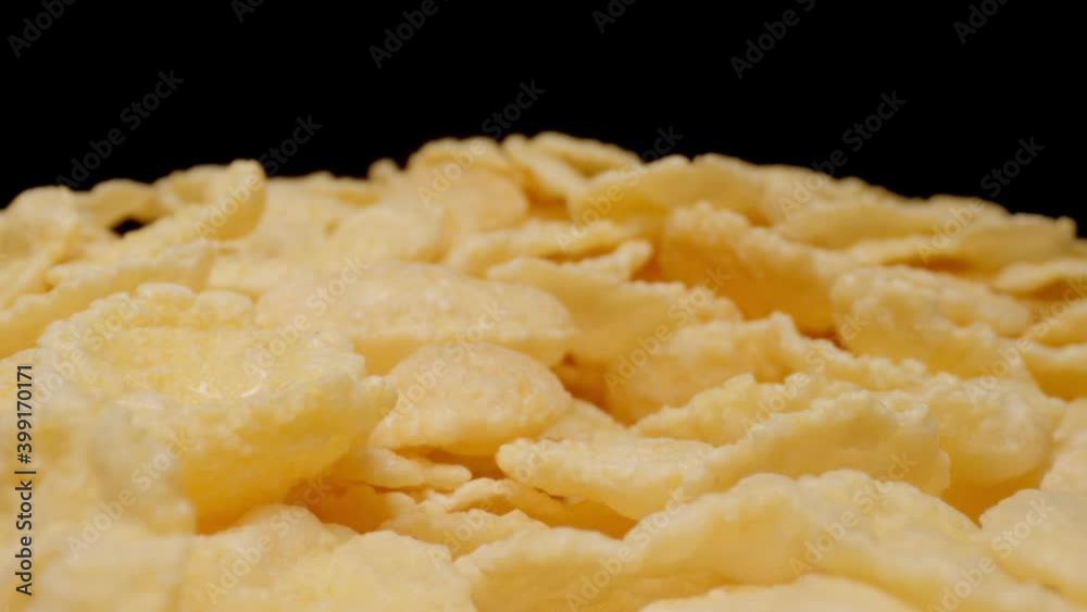 MACRO: Motion over sweet corn flakes on a black background MACRO: Motion over sweet corn flakes on a black background