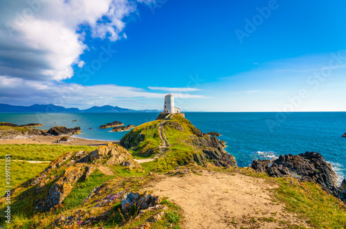 Lighthouse on Llanddwyn Island and Snowdonia mountains in background. North Wales. UK photo