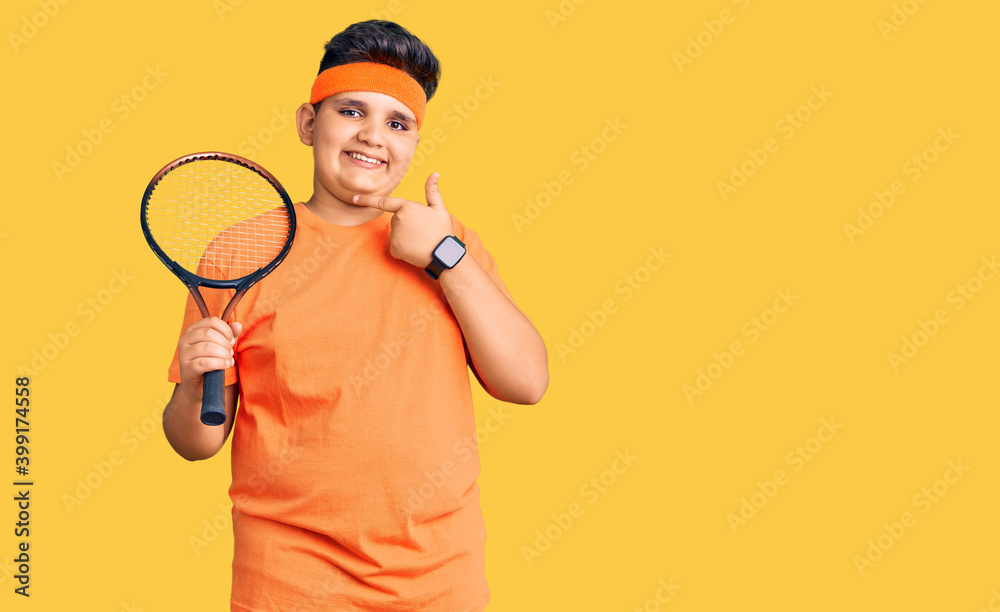 Little boy kid playing tennis holding racket smiling happy pointing with hand and finger Little boy kid playing tennis holding racket smiling happy pointing with hand and finger