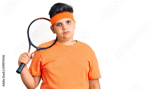 Little boy kid playing tennis holding racket thinking attitude and sober expression looking self confident © Krakenimages.com