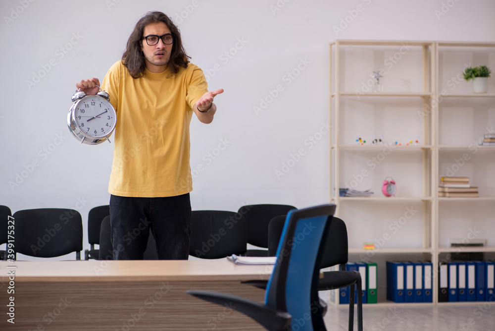 Young male student waiting for teacher in the classroom Young male student waiting for teacher in the classroom