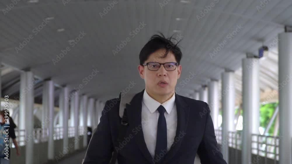 Confidence Asian businessman office worker in suit with backpack walking in rush hour at railway station to work in the morning. Business people hurry up going to working at city office district Confidence Asian businessman office worker in suit with backpack walking in rush hour at railway station to work in the morning. Business people hurry up going to working at city office district