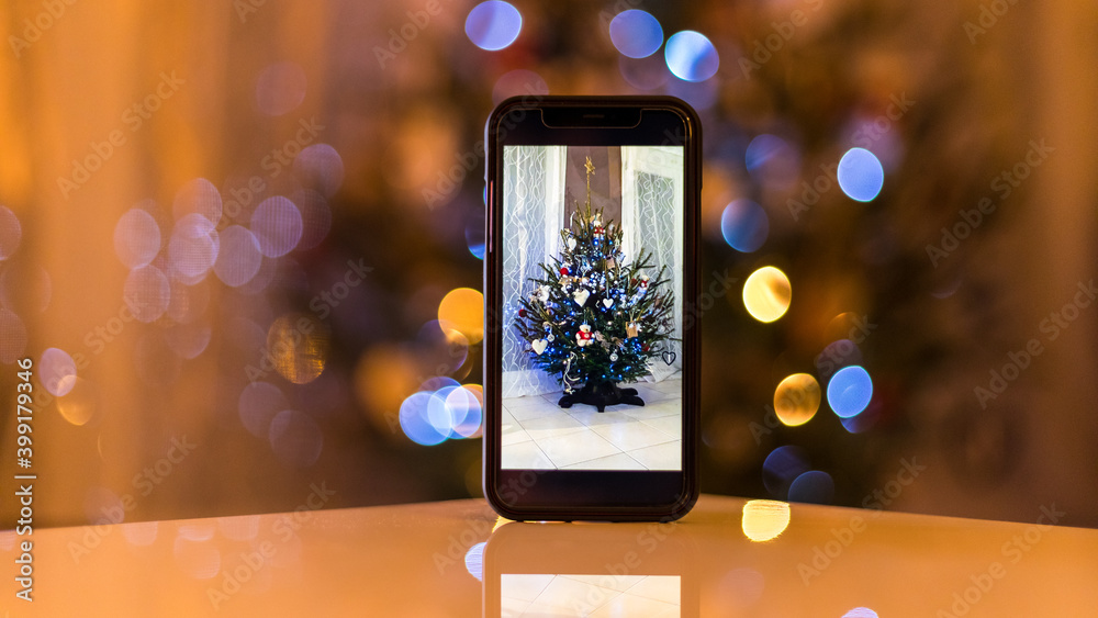 Christmas tree on a phone on the table Christmas tree on a phone on the table