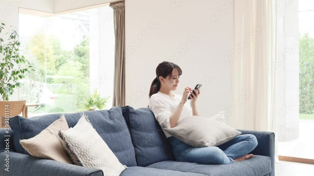 ソファーでスマホを使う女性 ソファーでスマホを使う女性
