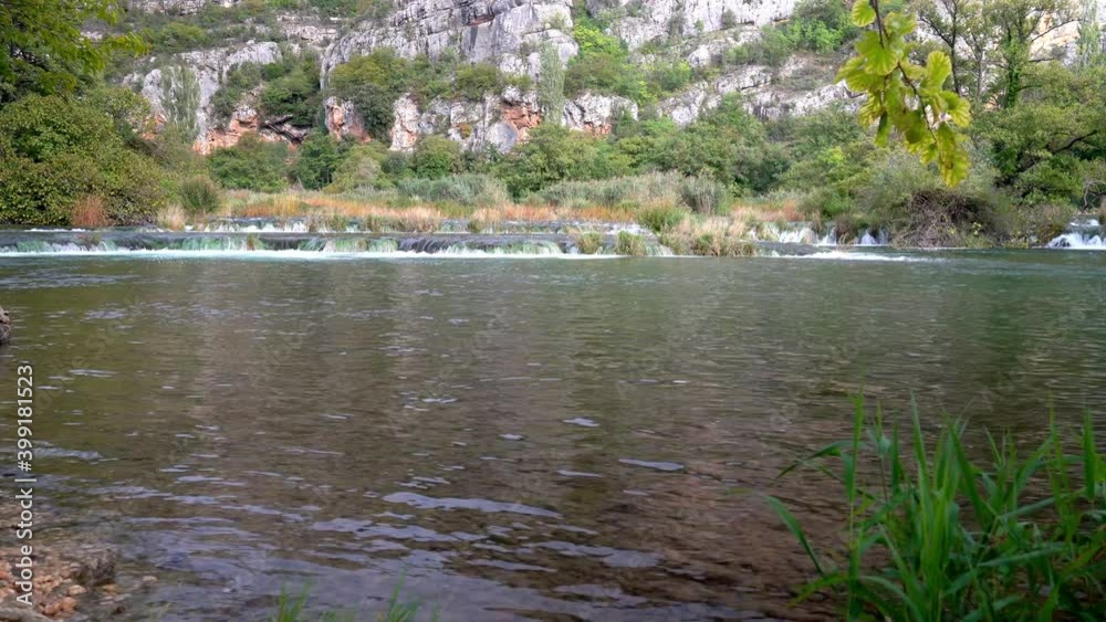 Short but wide and strong waterfalls from one pond to another submerging grass in Krka National Park in Croatia in fall Short but wide and strong waterfalls from one pond to another submerging grass in Krka National Park in Croatia in fall