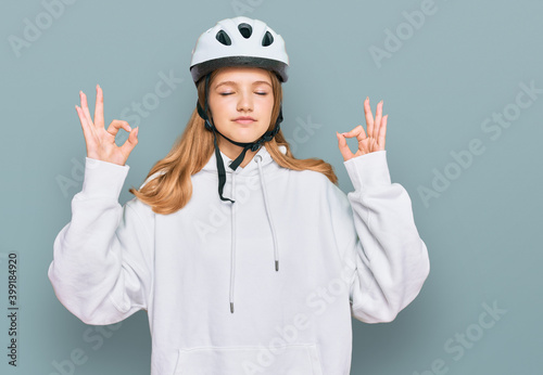 Beautiful young caucasian girl wearing bike helmet relax and smiling with eyes closed doing meditation gesture with fingers. yoga concept. © Krakenimages.com