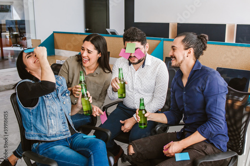 young latin business professionals celebrating a success with beers in creative office in Mexico city