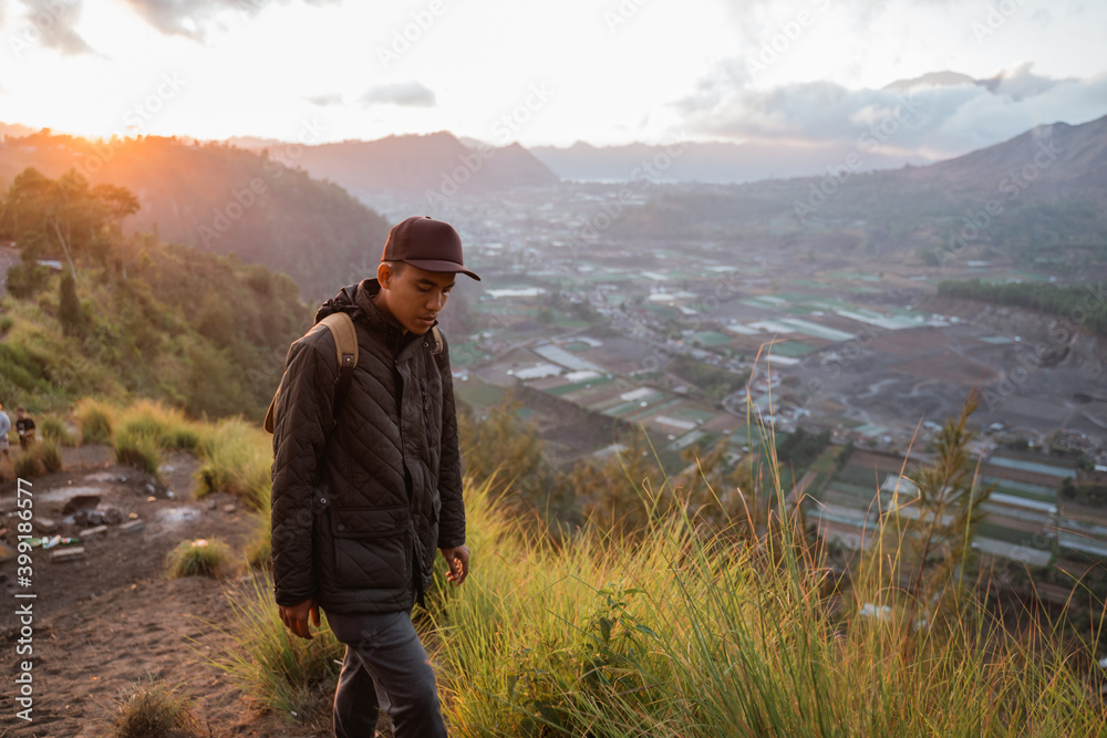 Portrait adventurous man with a backpack captures the moment. Beautiful mountain scenery in the morning