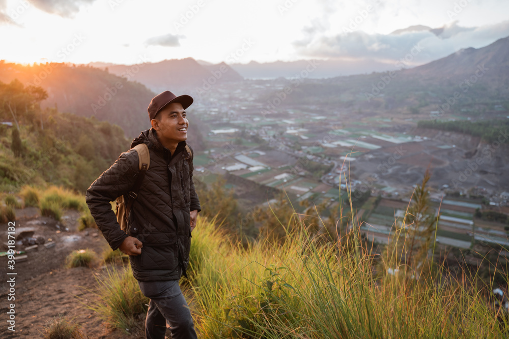 Portrait adventurous man with a backpack captures the moment. Beautiful mountain scenery in the morning Portrait adventurous man with a backpack captures the moment. Beautiful mountain scenery in the morning