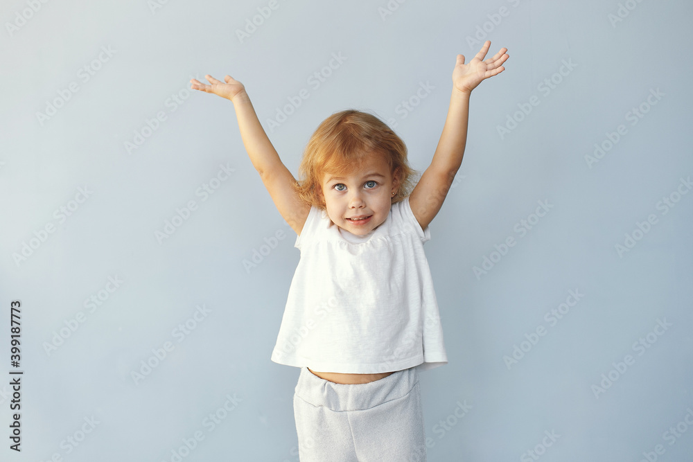 Child in a studio. Little girl on a blue background. Girl in a white t-shirt. Child in a studio. Little girl on a blue background. Girl in a white t-shirt.