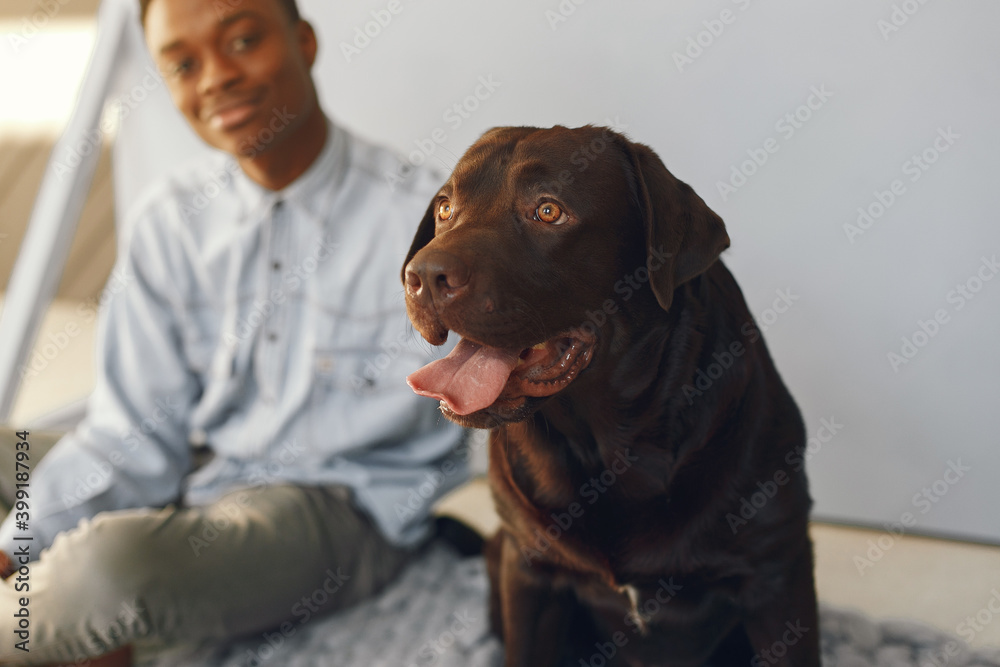 Black man. Guy in a blue shirt. Man with dog in a studio. Black man. Guy in a blue shirt. Man with dog in a studio.