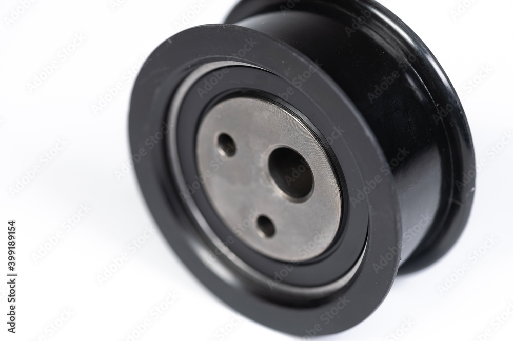New timing belt tensioner roller close-up macro shot on gray background New timing belt tensioner roller close-up macro shot on gray background