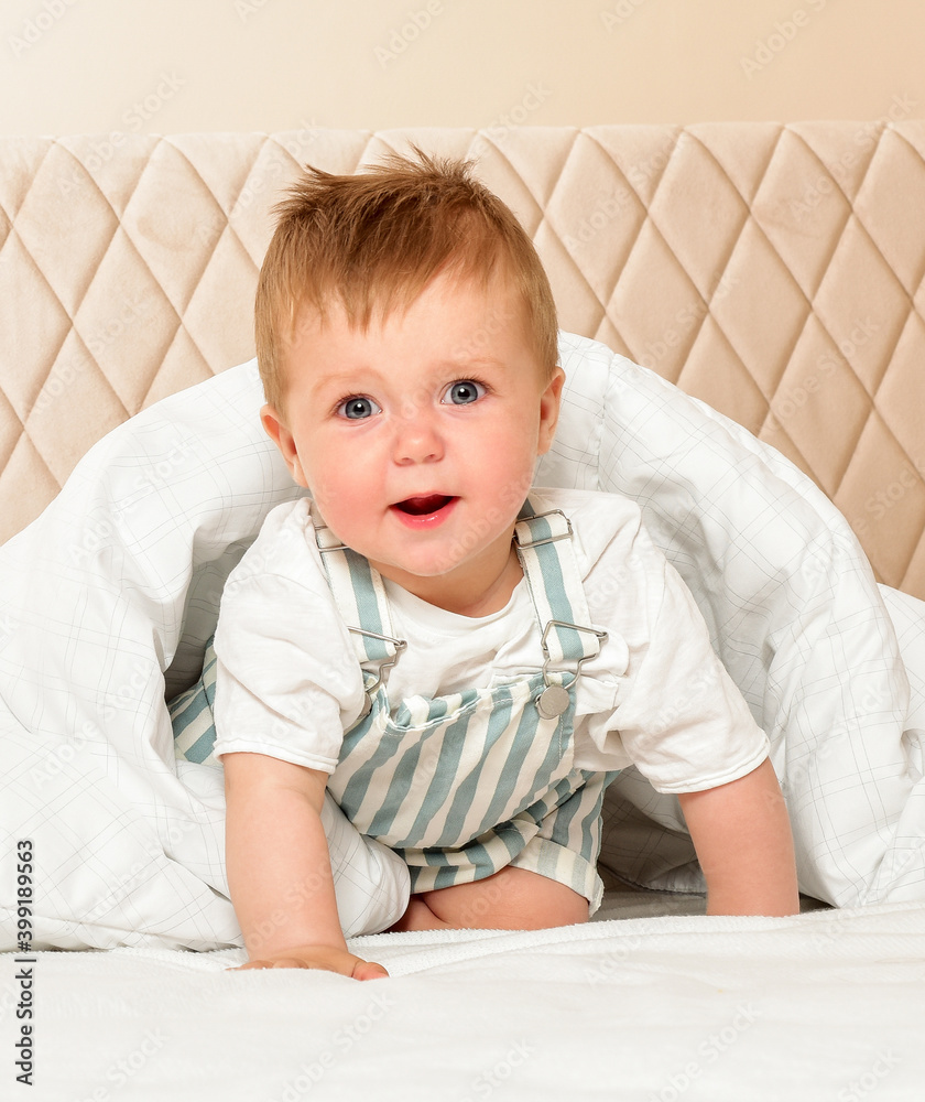 Fototapeta premium Happy cheerful baby in the interior of the bedroom. Laughter.