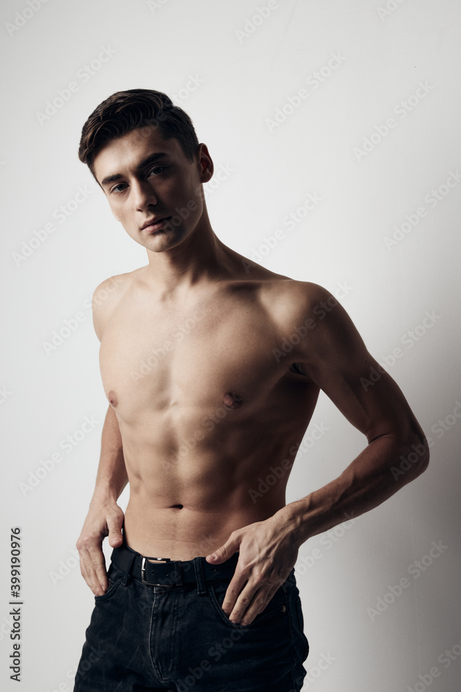 Muscular guy in pants nude torso cropped view over gray background
