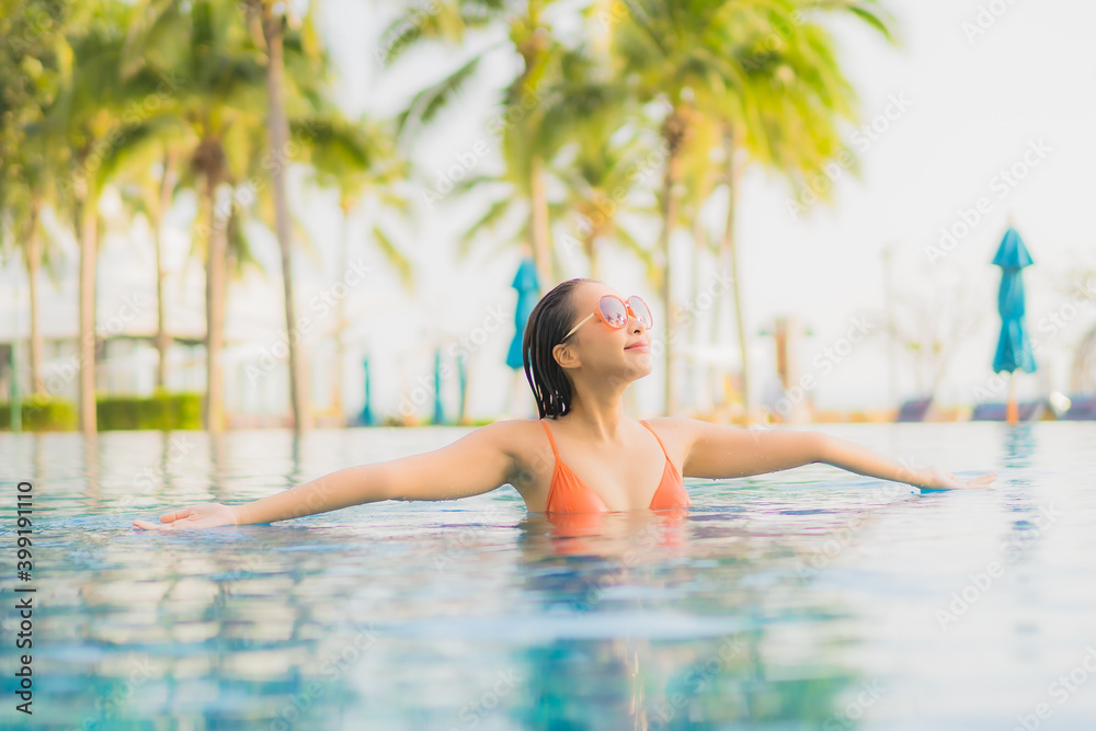 Portrait beautiful young asian woman relax smile leisure around outdoor swimming pool nearly sea beach ocean