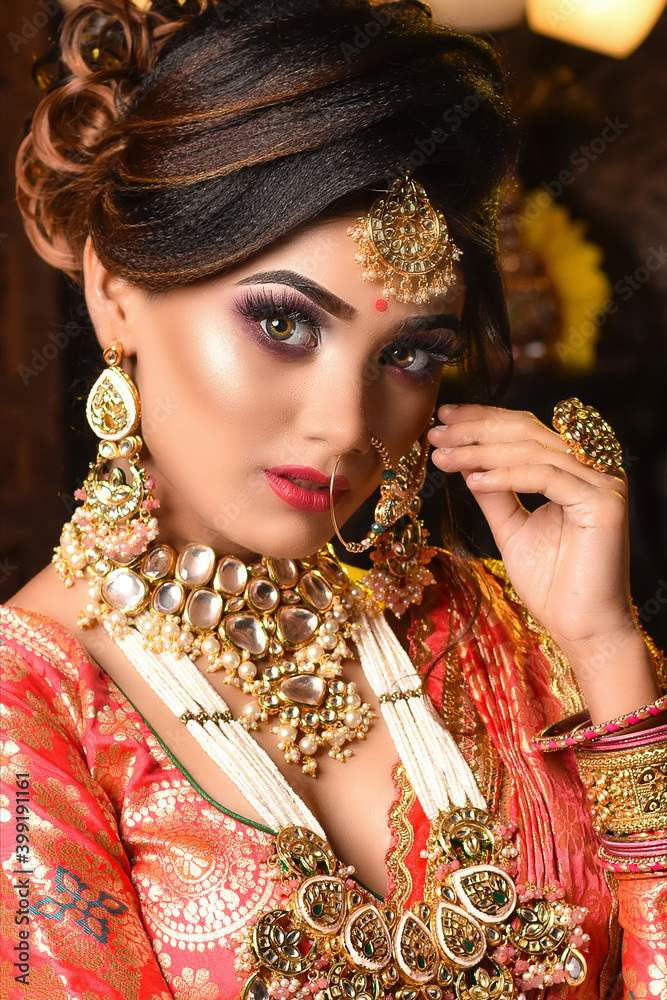 Close up Portrait of very beautiful young Indian bride in luxurious bridal  costume with makeup and heavy jewellery in studio lighting indoor. Wedding  fashion. Stock Photo | Adobe Stock