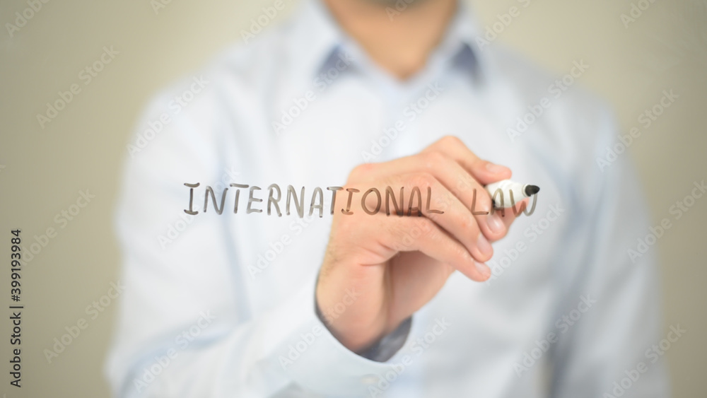 International Law, man writing on transparent screen International Law, man writing on transparent screen