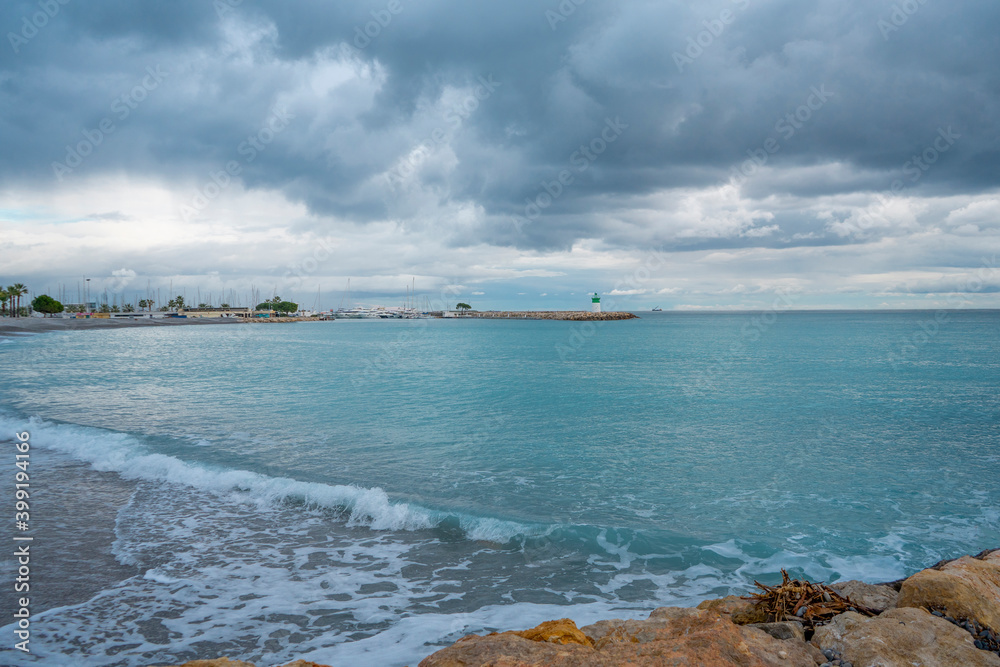 Lighthouse on the beautiful azure sea under the cloudy sky. Panoramic sea view Lighthouse on the beautiful azure sea under the cloudy sky. Panoramic sea view