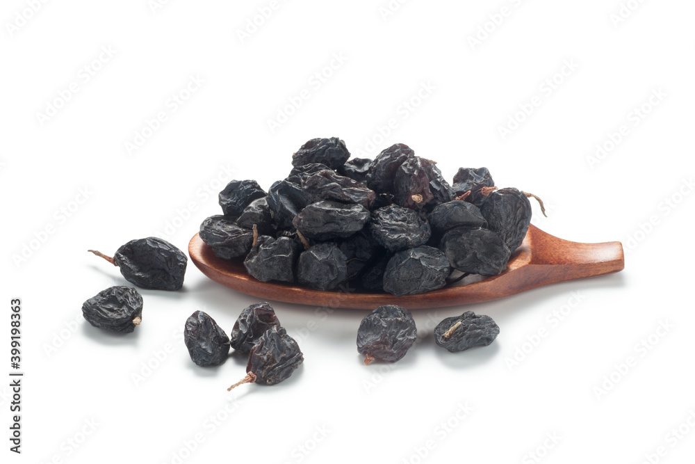 Black currant raisins in a wooden spoon. Isolated on white background. Black currant raisins in a wooden spoon. Isolated on white background.
